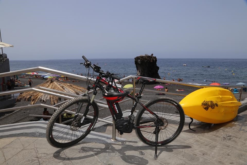 Sommerdunst und Hitze wabern über La Palma: Es gibt dennoch ganz Harte, die bei diesem Wetter radeln - andere ziehen kühleres Ocean-Kajaking vor. Allerdings handelt es sich bei dem Rad um ein E-Bike von La Palma 24, mit dem man selbst noch bei Temperaturen um die 30 Grad relativ entspannt über die Insel kommt. Foto: Michael Kreikenbom