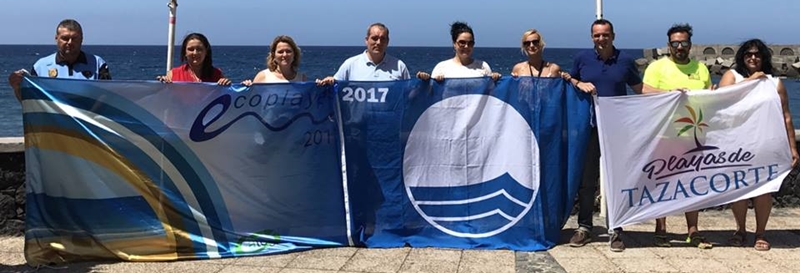Großer Bahnhof fürs Hissen der Sommerfahnen an der Playa von Tazacorte: Sogar Inseltourismusrätin Alicia Vanoostende (Bildmitte) kam vorbei. Insgesamt wedelt die Blaue Flagge der FEE an fünf Stränden von La Palma - das Symbol für saubere Playas und Badesicherheit darf auch am Strand von Puerto Naos, Charco Verde, Bajamar und Los Cancajos gehisst werden. Foto: Loli