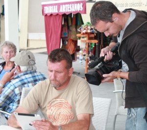 Dreharbeiten in Puerto Naos: Wesley filmt Leute in der Wifi-Zone der Beach Bar, die das La Palma 24-Journal lesen.